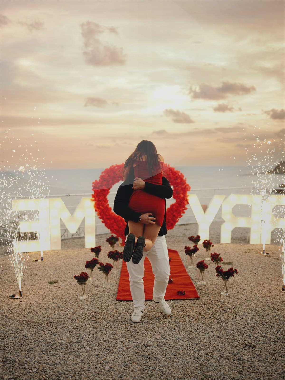 Couple standing together on the beach at sunset.
