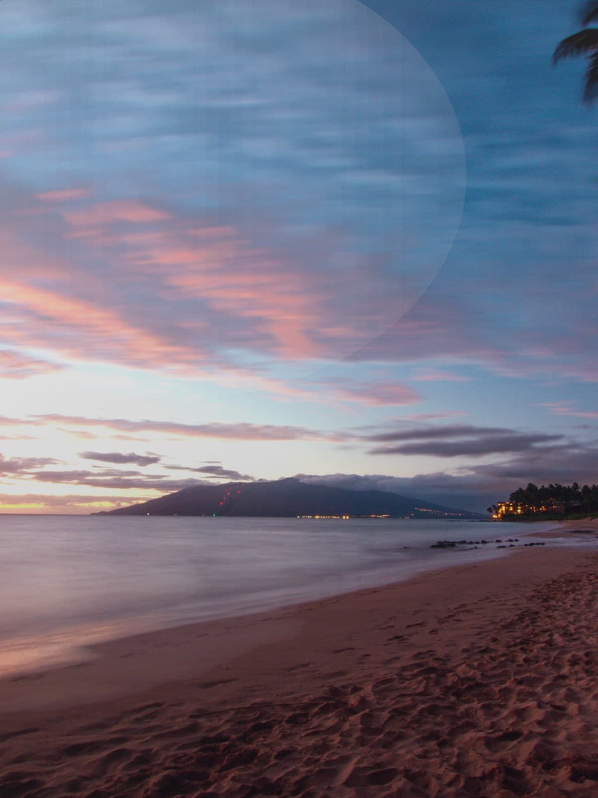 Couple embracing on a beach near sunset.