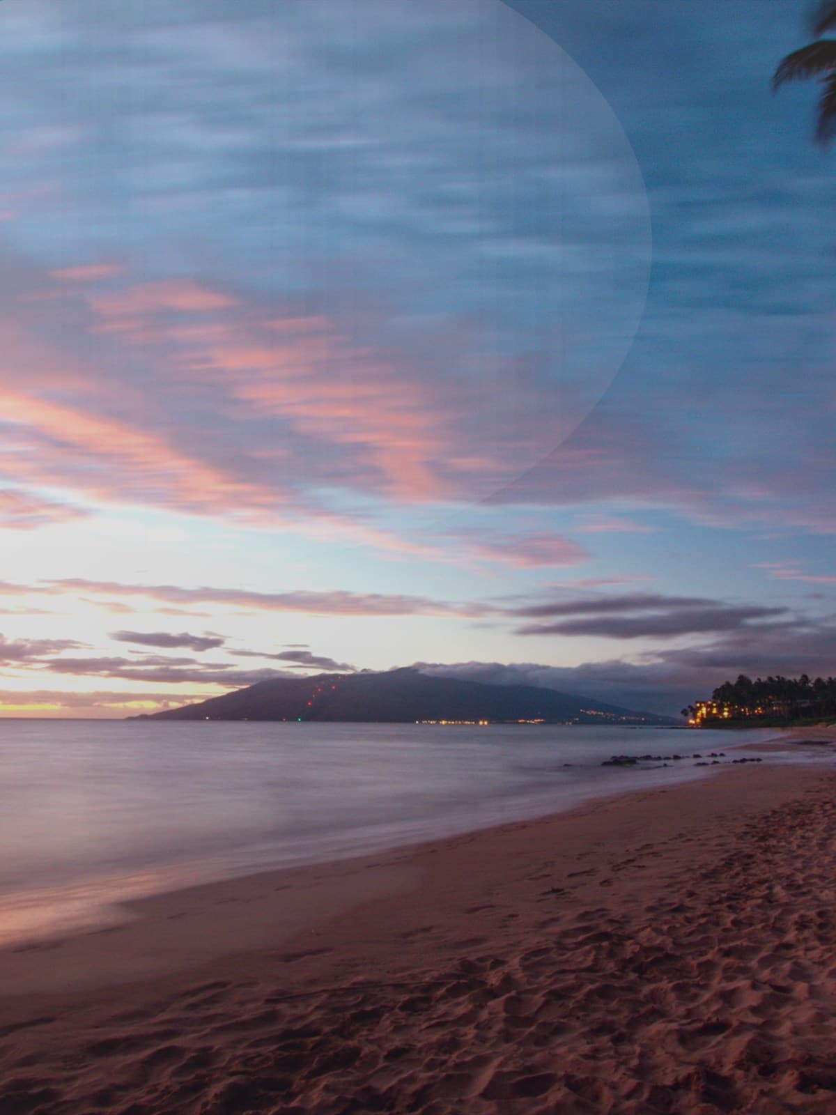 Couple walking on the beach at sunset.