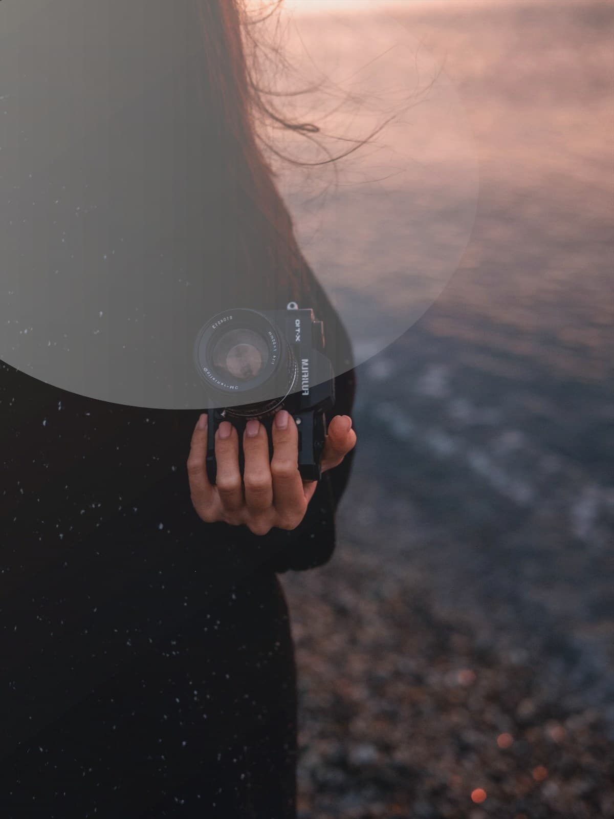 Couple standing together on the beach at sunset.