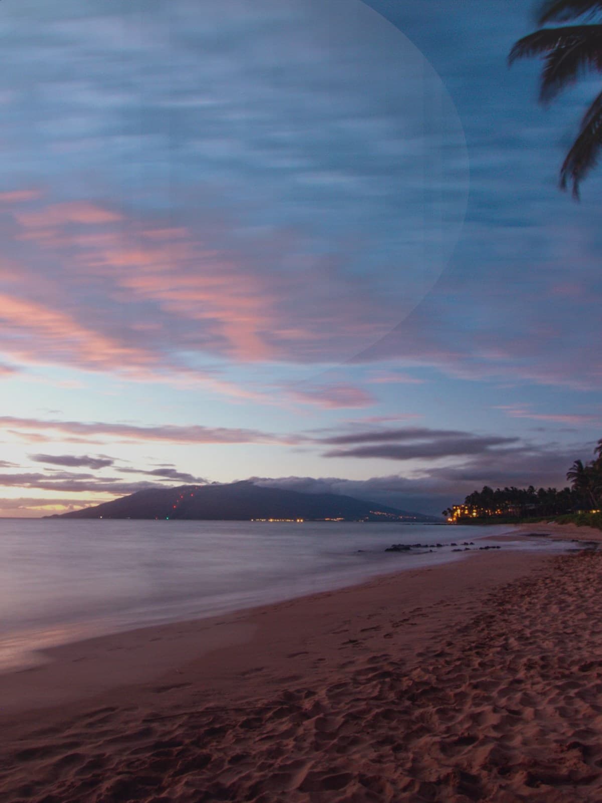 Pregnant woman standing on the beach at sunset.