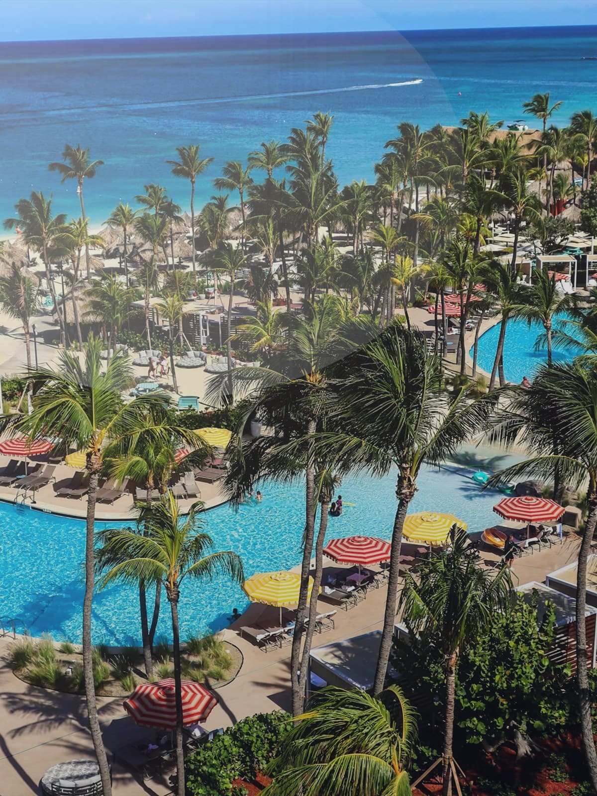 Bride and groom standing together on the beach by the ocean.